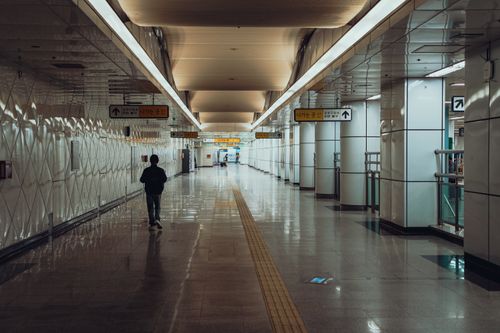 Free A person walking through a modern subway corridor in Suwon, South Korea, during the day. Stock Photo