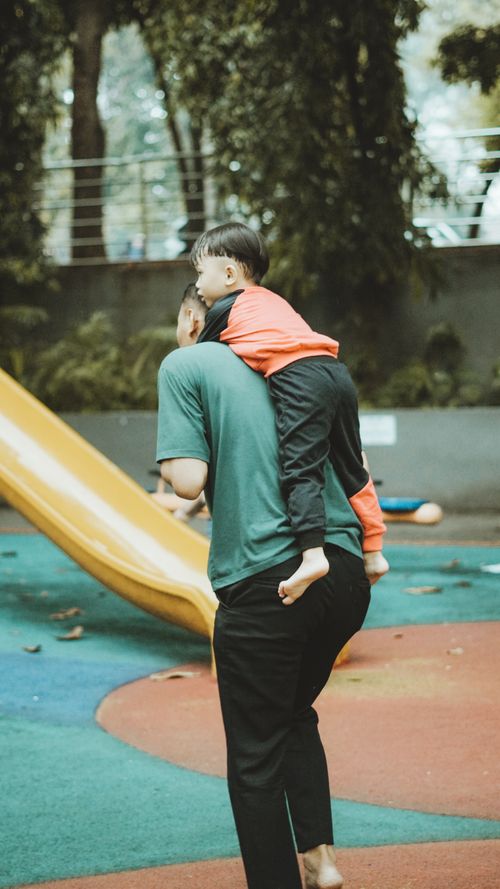 Free Father giving child a piggyback ride in colorful urban playground in Indonesia. Stock Photo