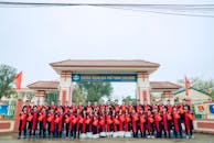 Group of Students in Graduation Robes at School Gate