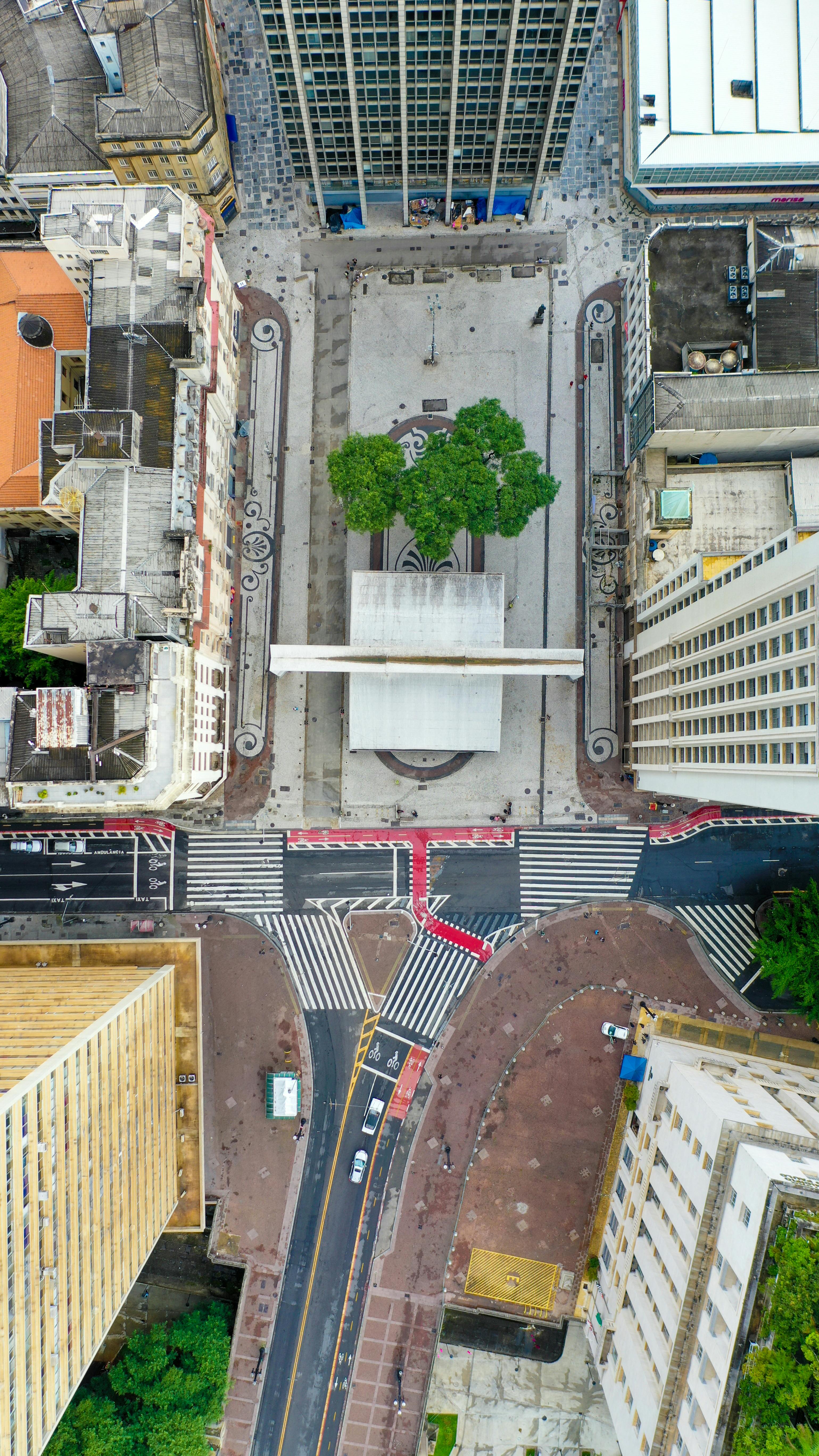 Drone captures geometric urban landscape with roads and plaza.