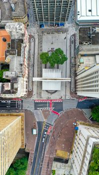 Drone captures geometric urban landscape with roads and plaza.