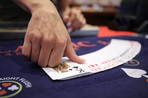 Person Holding White and Red Playing Cards