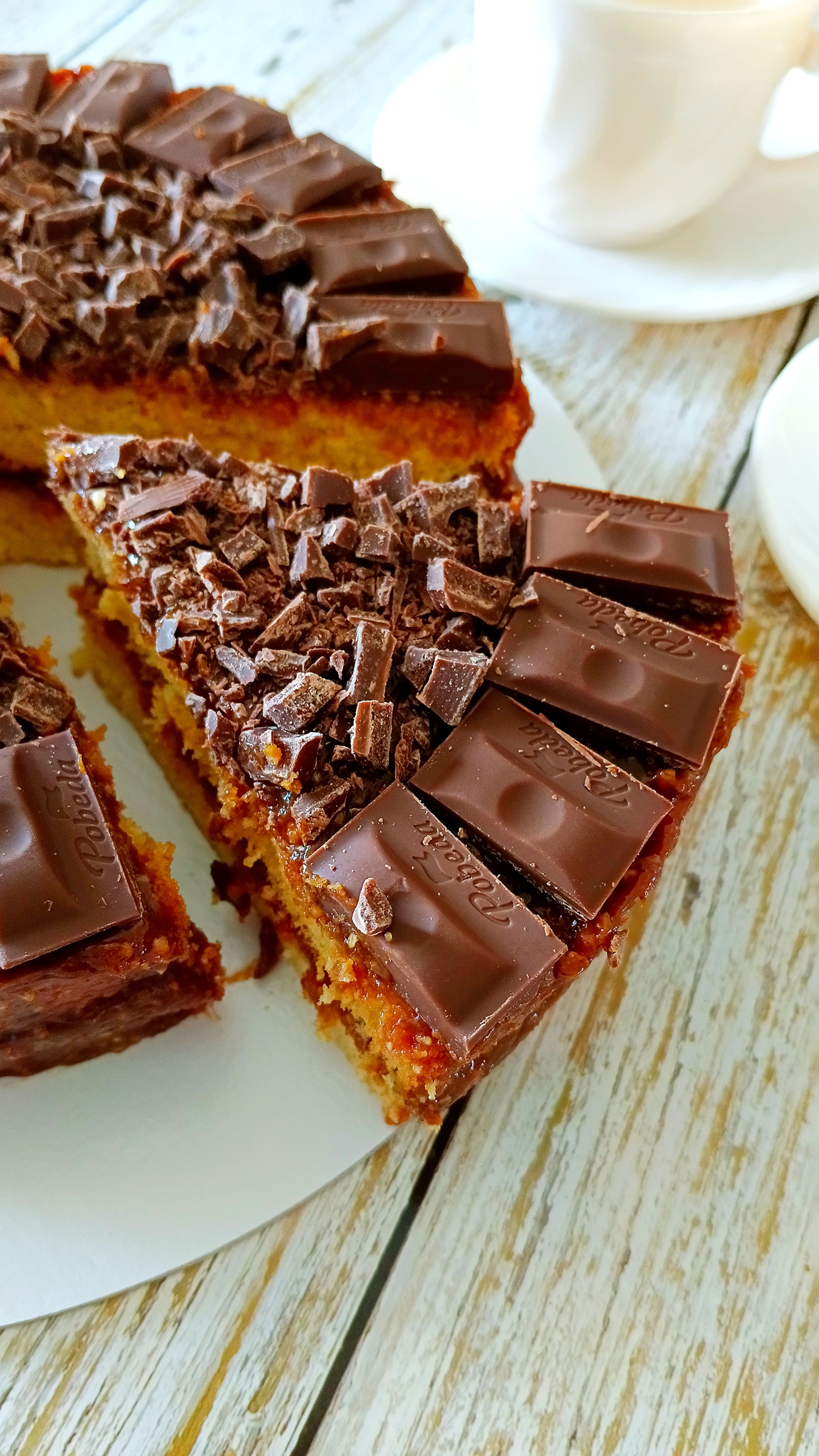 Mouth-watering chocolate cake topped with chocolate pieces, ideal for dessert lovers.