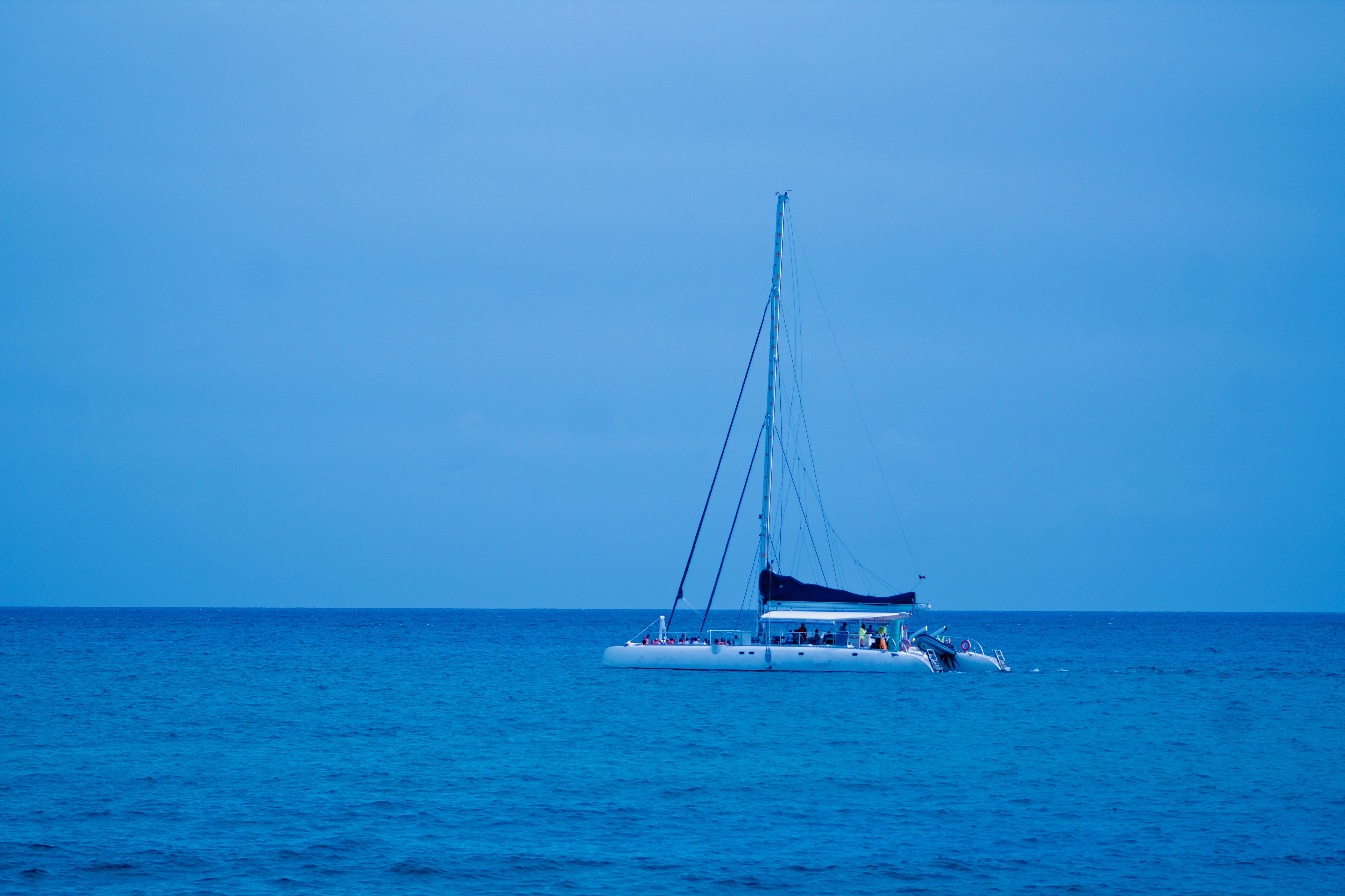Ultimate Luxury Catamaran Cruise from Oahu Review: An Unforgettable Hawaiian Sailing Adventure Review 2026 - Serene scene of a sailboat floating on calm blue waters during twilight.