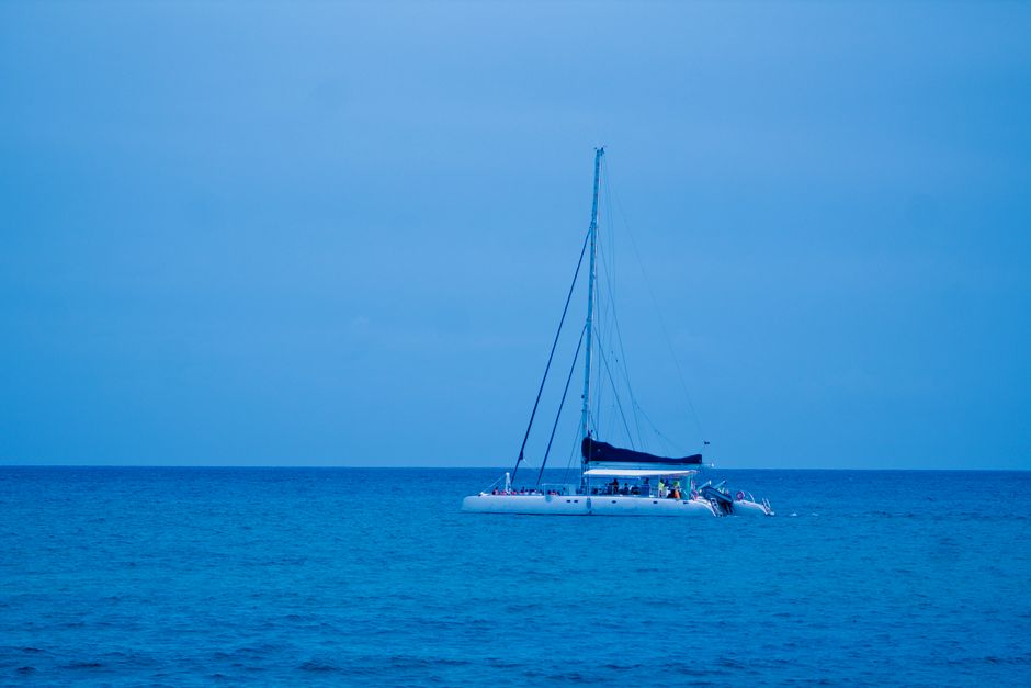 Ultimate Luxury Catamaran Cruise from Oahu Review: An Unforgettable Hawaiian Sailing Adventure Review 2026 - Serene scene of a sailboat floating on calm blue waters during twilight.