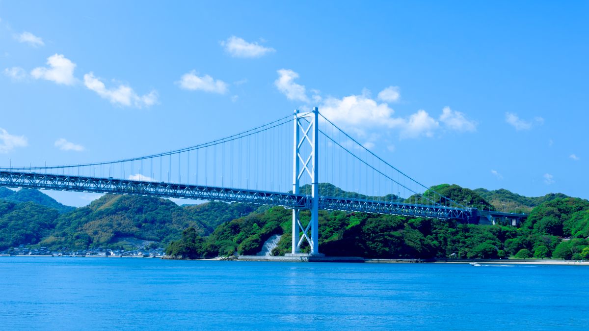 Suspension bridge over the Seto Inland Sea on the Shimanami Kaido — turquoise blue water and green island hills