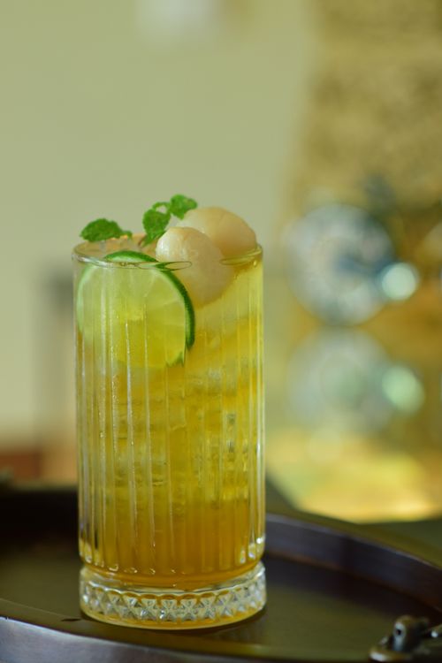 Free Chilled lychee and lime sparkling cocktail garnished with mint leaves, ideal for summer. Stock Photo