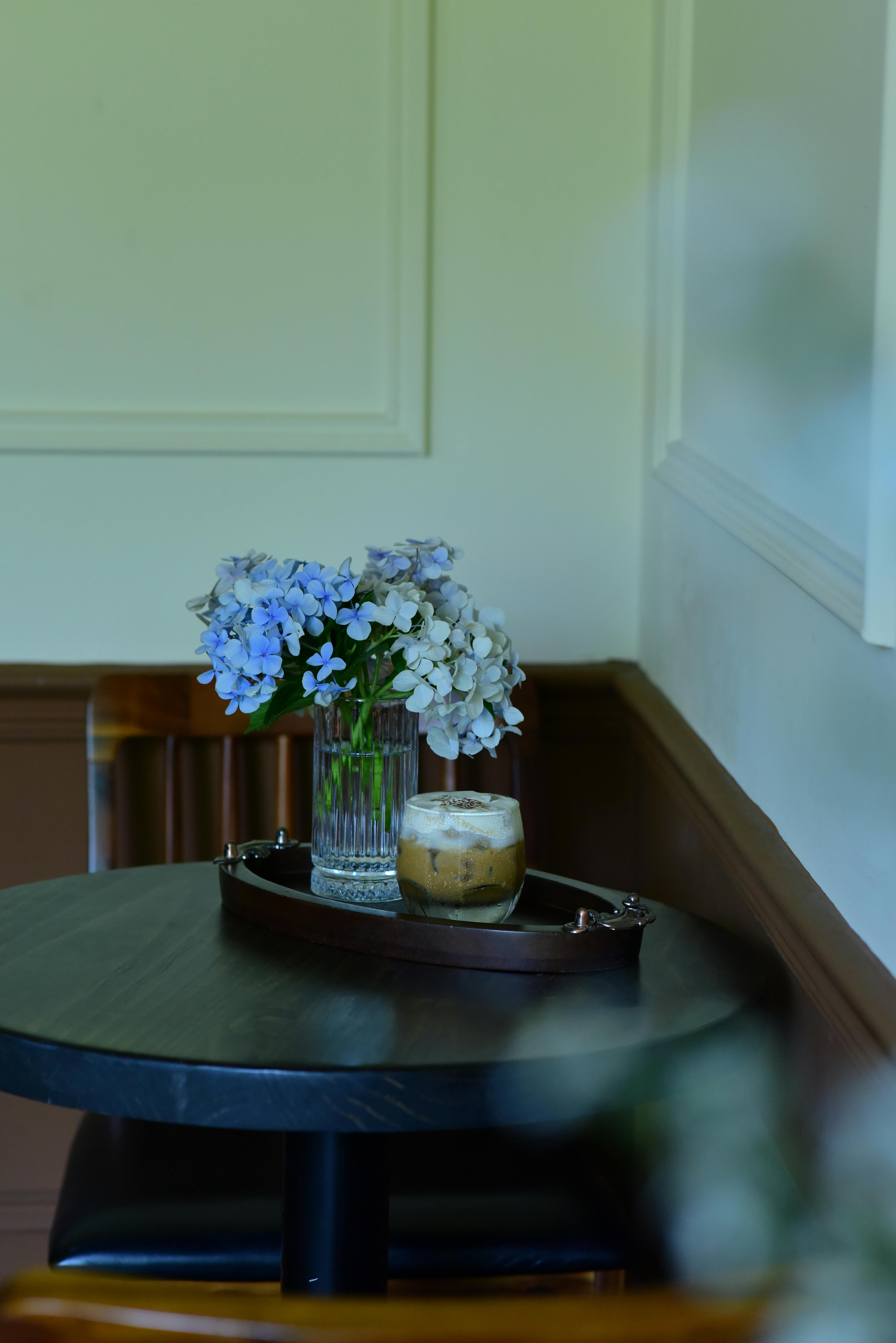 Gratuit O măsuță de cafea confortabilă pentru interior, cu un buchet de hortensii și o cafea cu gheață. Fotografie de stoc