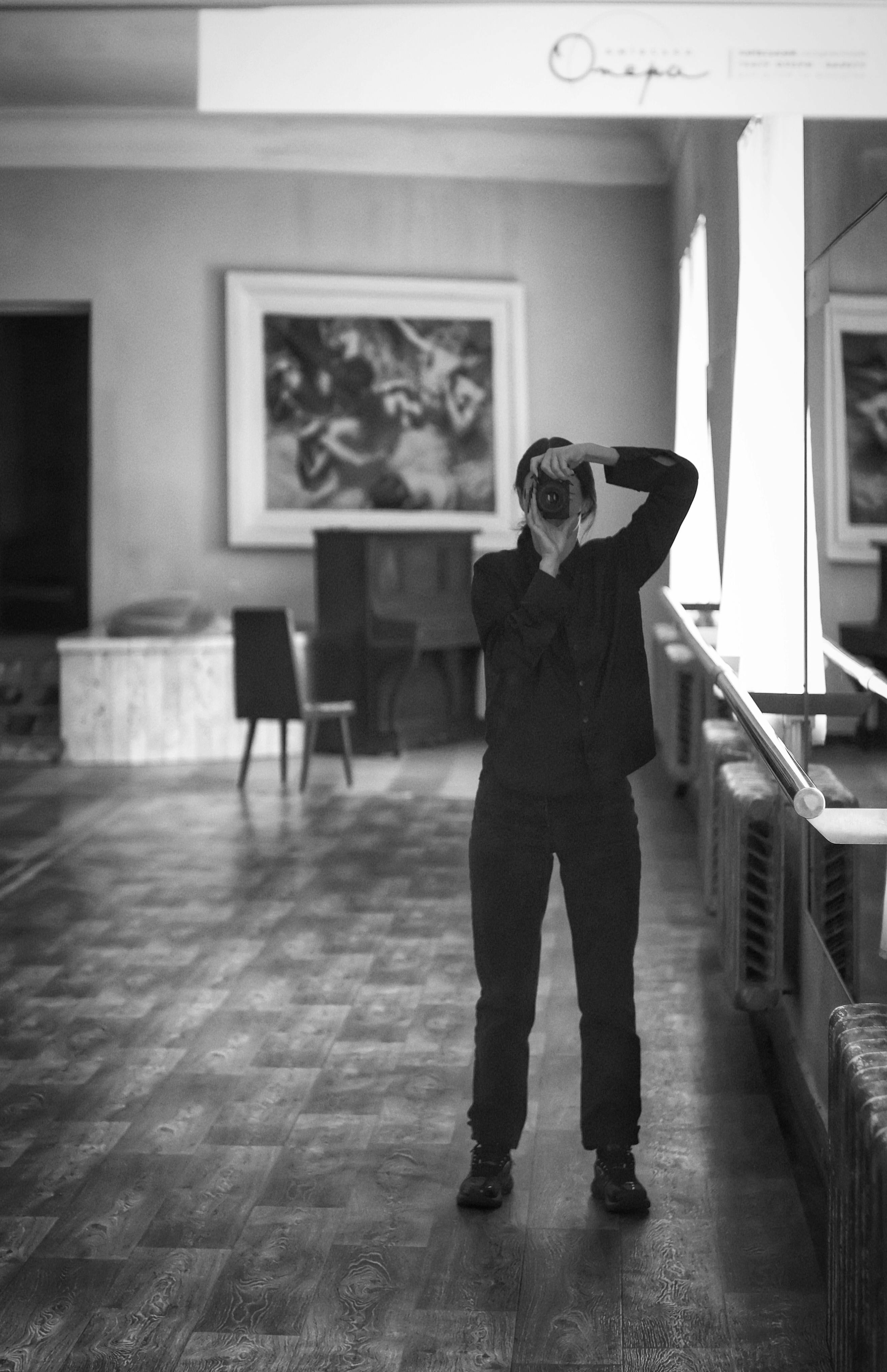 Capturing a photographer taking a shot in a minimalist indoor setting.