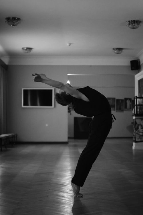 Free A dancer gracefully arches back in a black and white studio setting, capturing motion and expression. Stock Photo