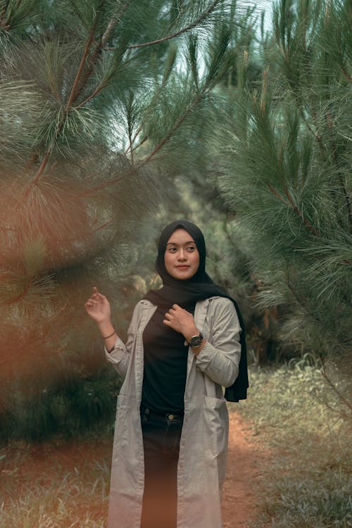 Woman Standing Between Trees