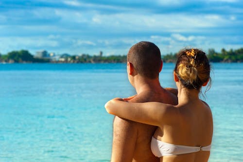 Free Woman Embracing Man Near Water Stock Photo