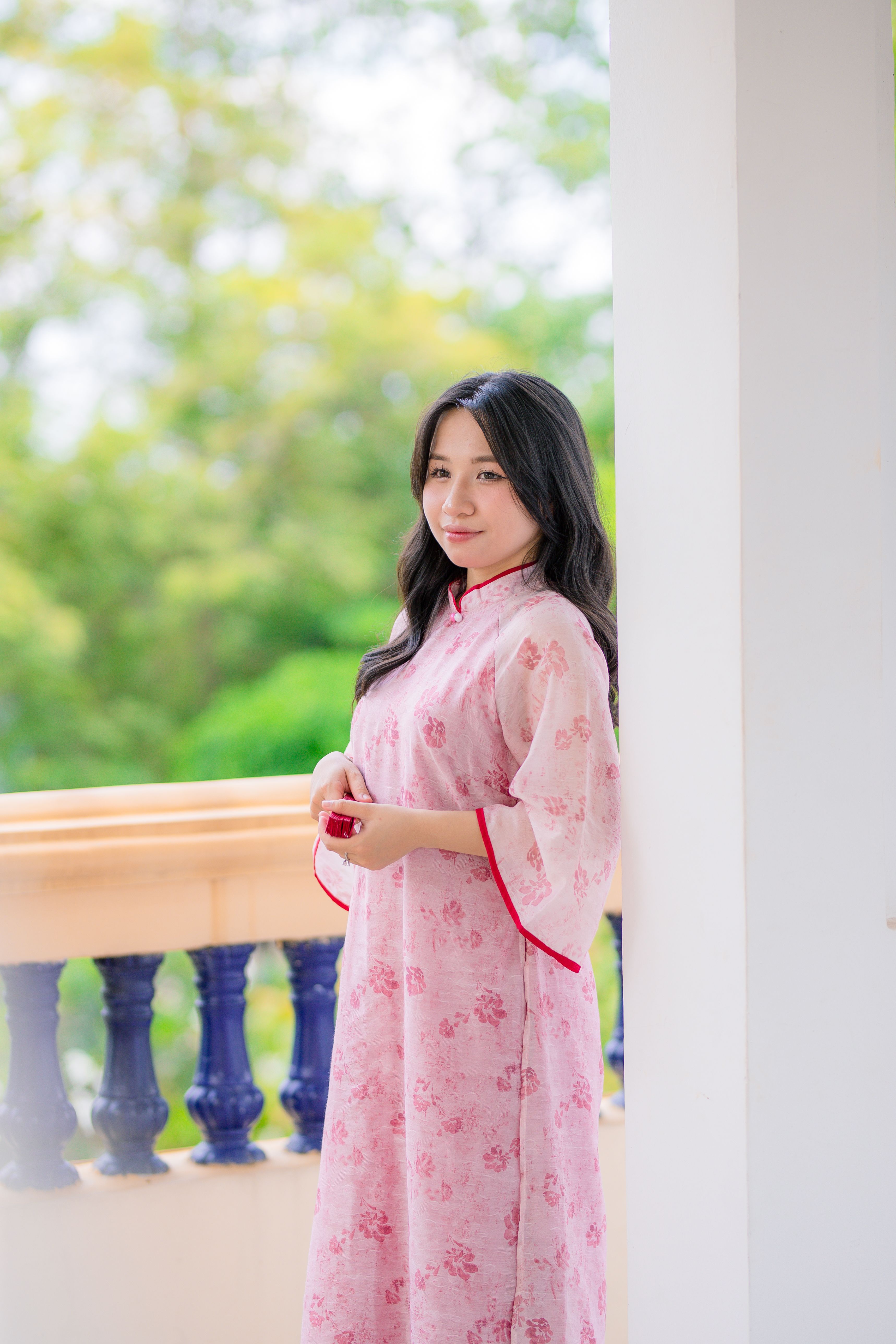 Woman in Pink Floral Dress on Balcony Outdoors · Free Stock Photo