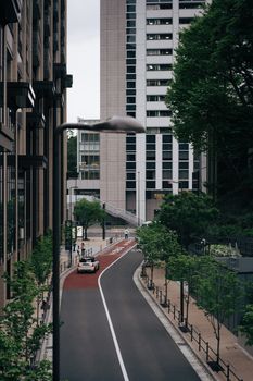 Explore a serene city street in Tokyo, showcasing modern architecture and greenery.
