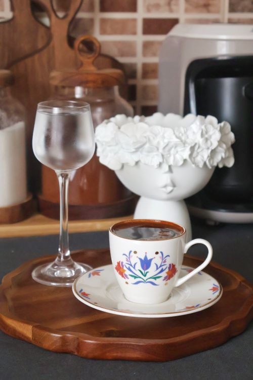 Free Stylish coffee cup and water glass on wooden tray in modern kitchen setting, perfect for a cozy atmosphere. Stock Photo