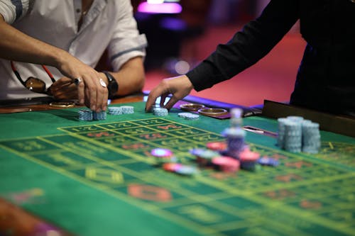 Free People Holding Poker Chips on the Table Stock Photo