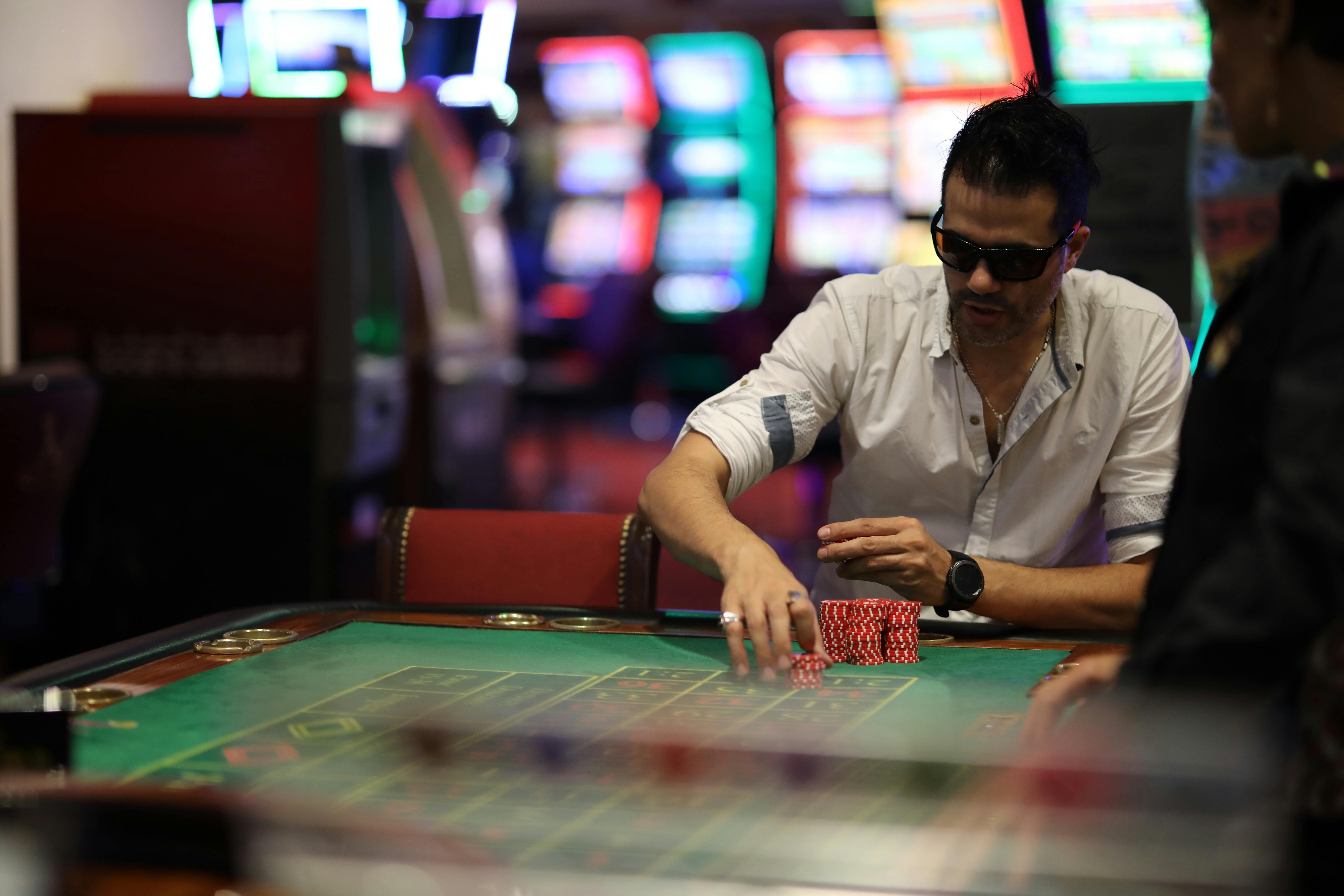 a man in sunglasses putting poker chips on the table