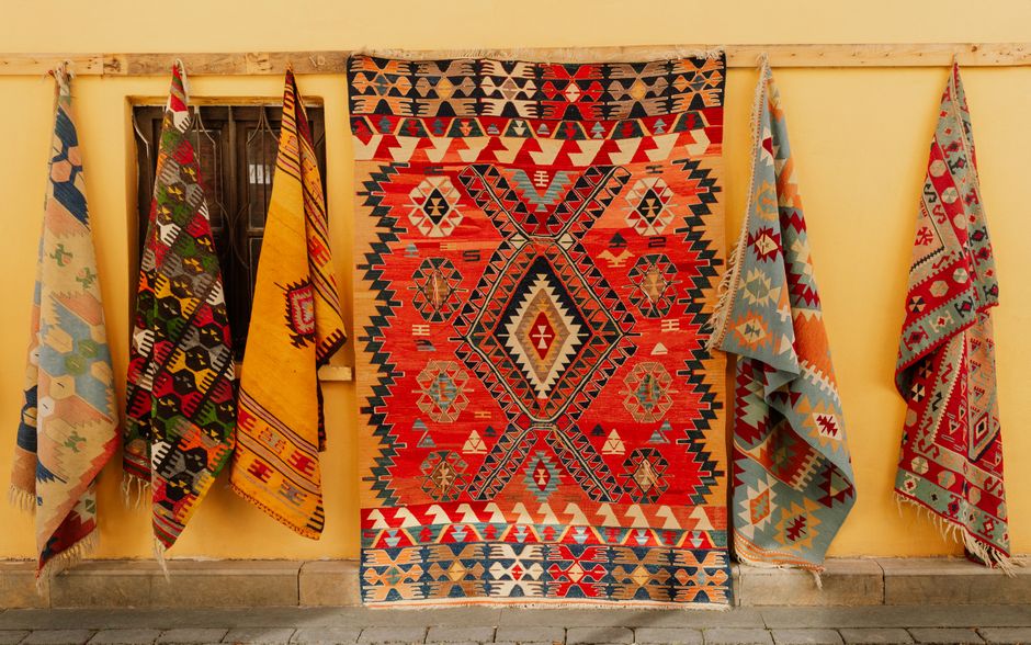 Colorful Turkish rugs hanging outdoors, showcasing traditional patterns and rich cultural heritage in Antalya, Türkiye.