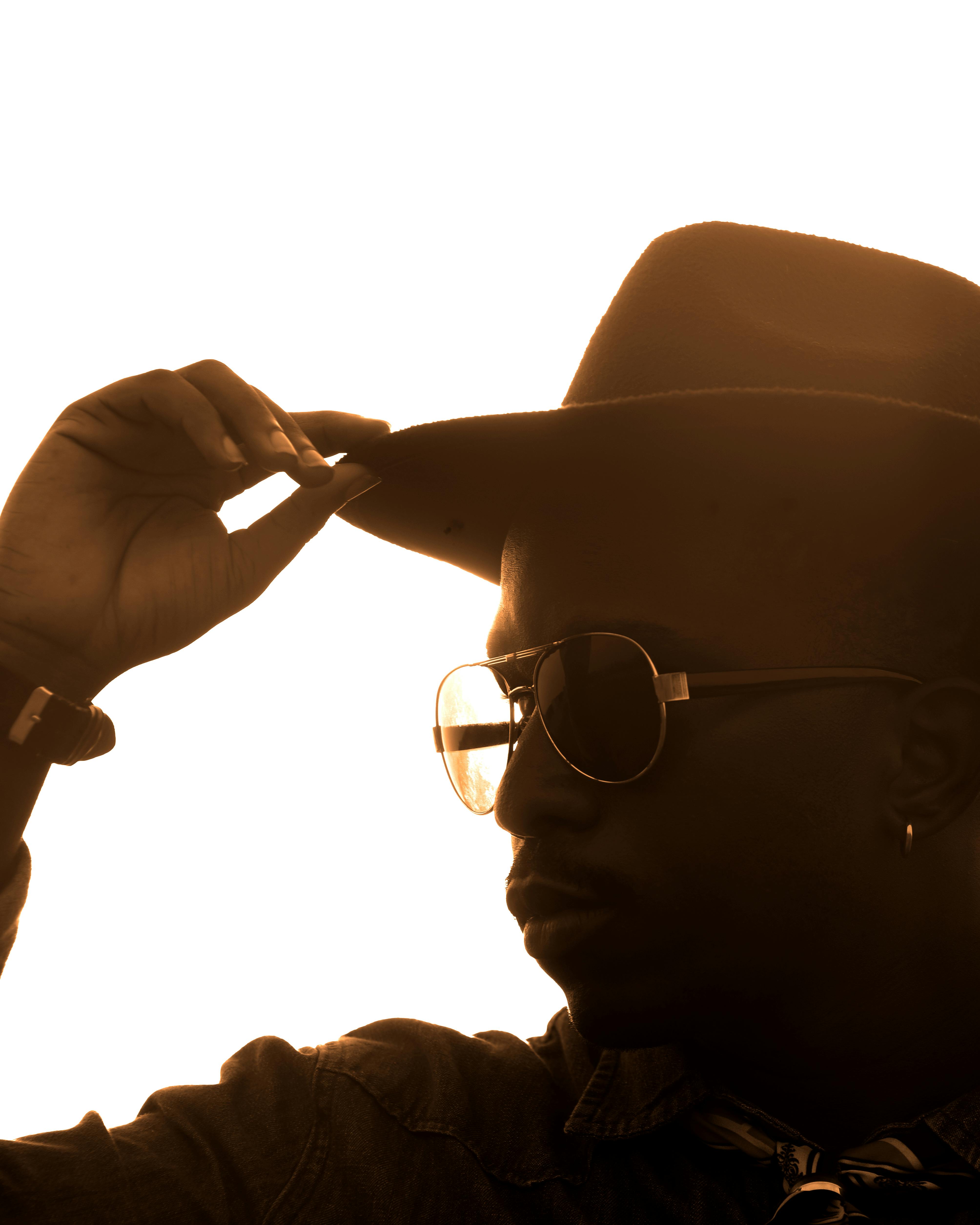 A silhouette of a man in a cowboy hat capturing a dramatic sunset moment.