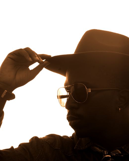 A silhouette of a man in a cowboy hat capturing a dramatic sunset moment.