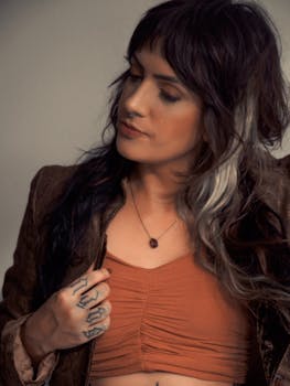 Portrait of a stylish woman with tattoos, unique two-tone hairstyle, and bohemian attire.