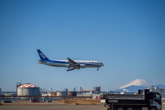 Airplane approaching runway with Mount Fuji in the background, showcasing travel and aviation.