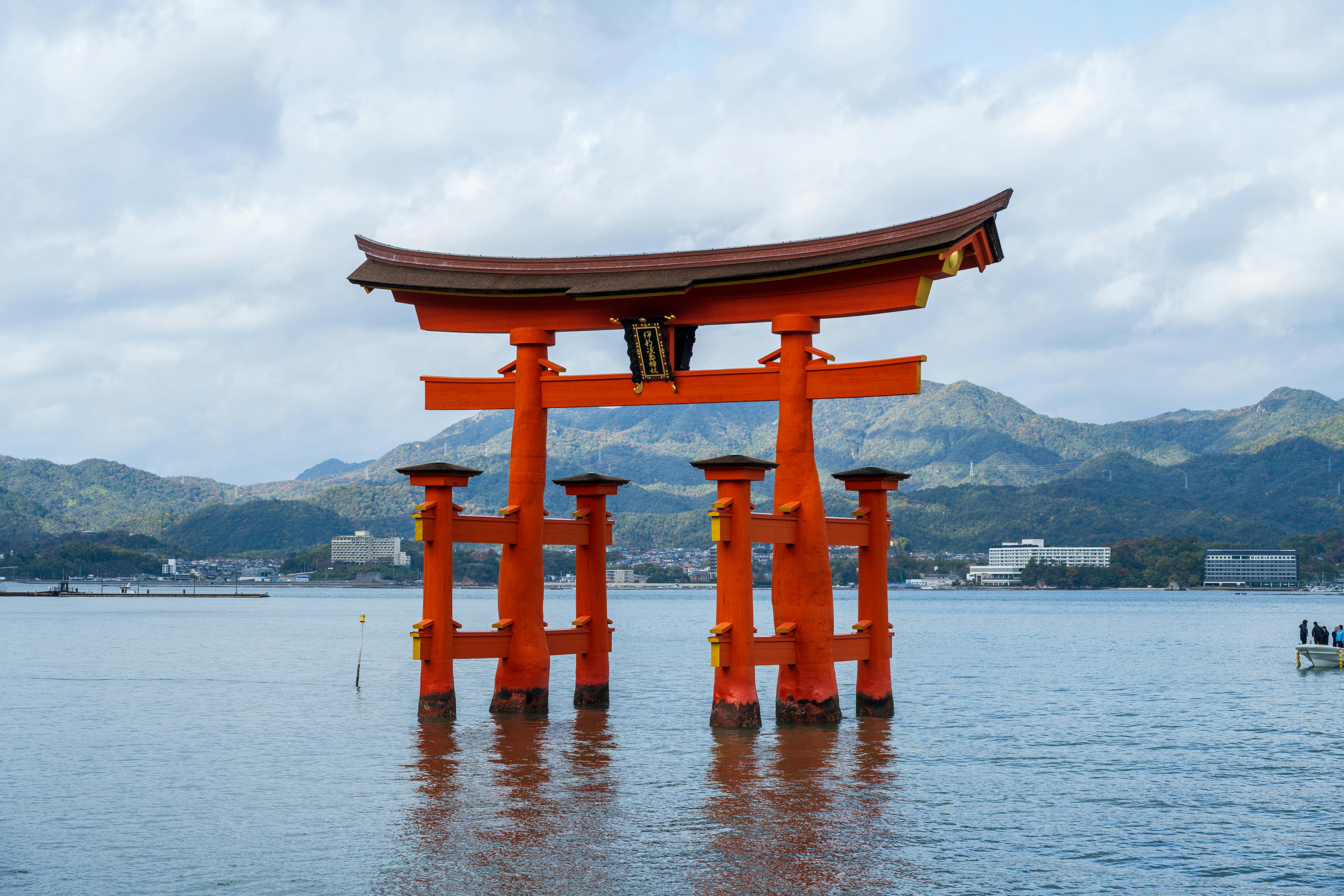Iconic Torii gate of Itsukushima Shrine stands amid tranquil waters, symbolizing serenity.