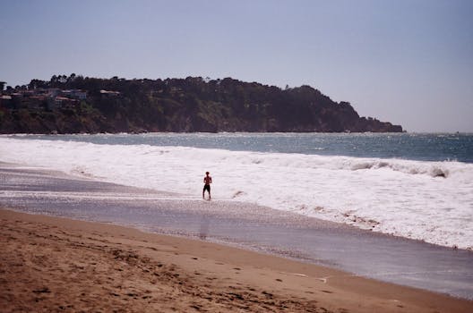 A lone figure enjoying the tranquil beauty of a San Francisco beach, California.