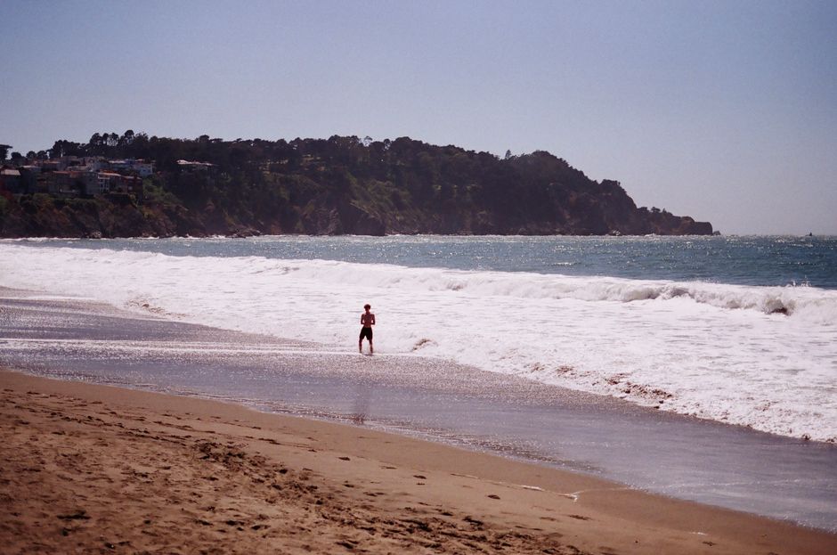 A lone figure enjoying the tranquil beauty of a San Francisco beach, California.