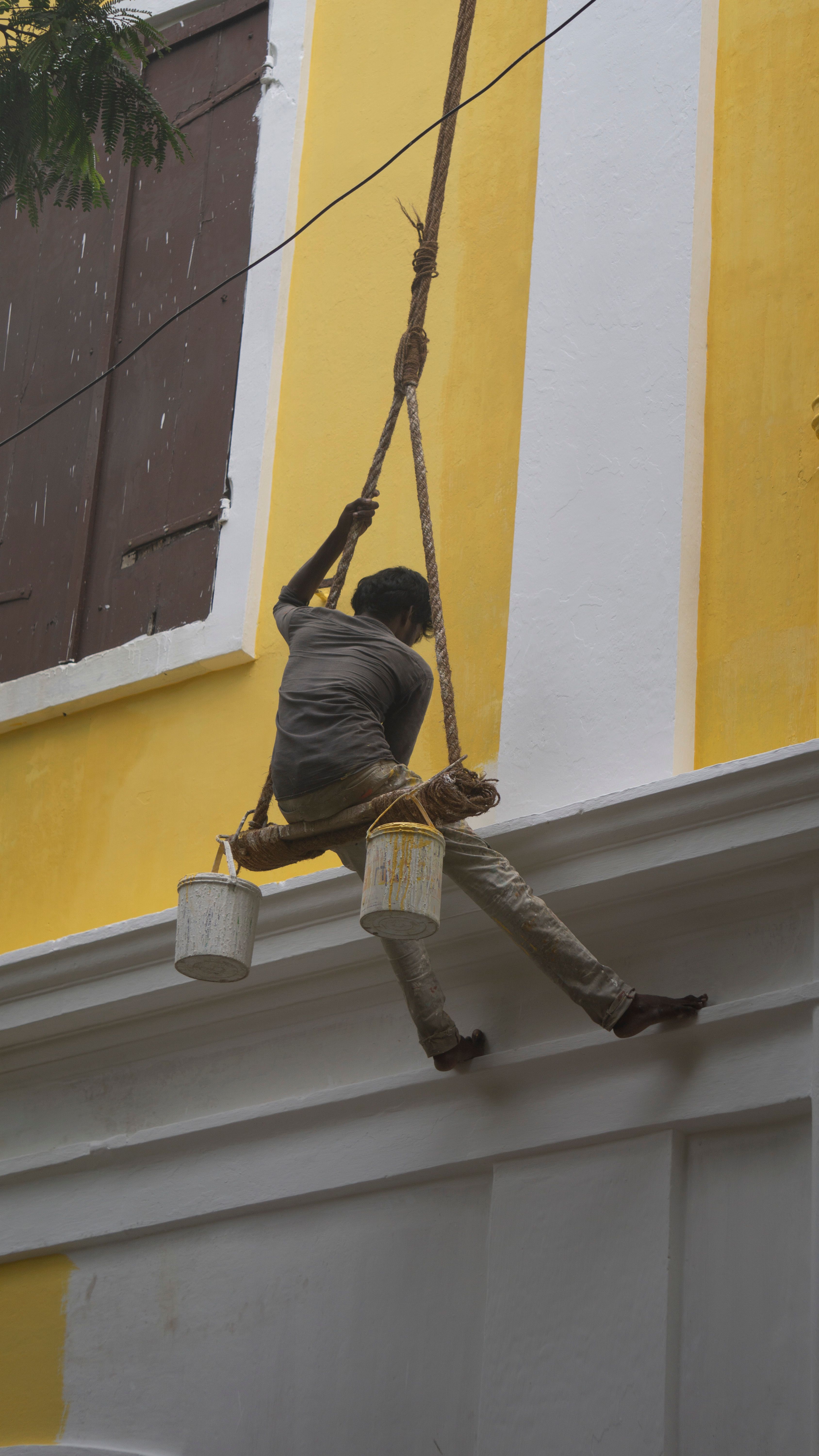 Worker Hanging on Rope Painting Building Exterior · Free Stock Photo