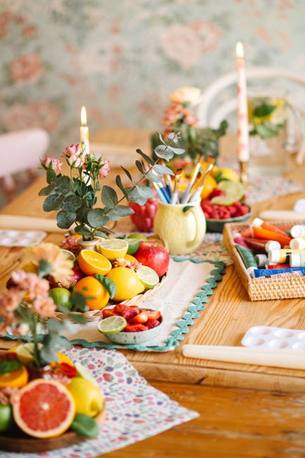 Vibrant fruit and floral arrangement set on a rustic wooden table, creating an artistic and cozy ambiance.