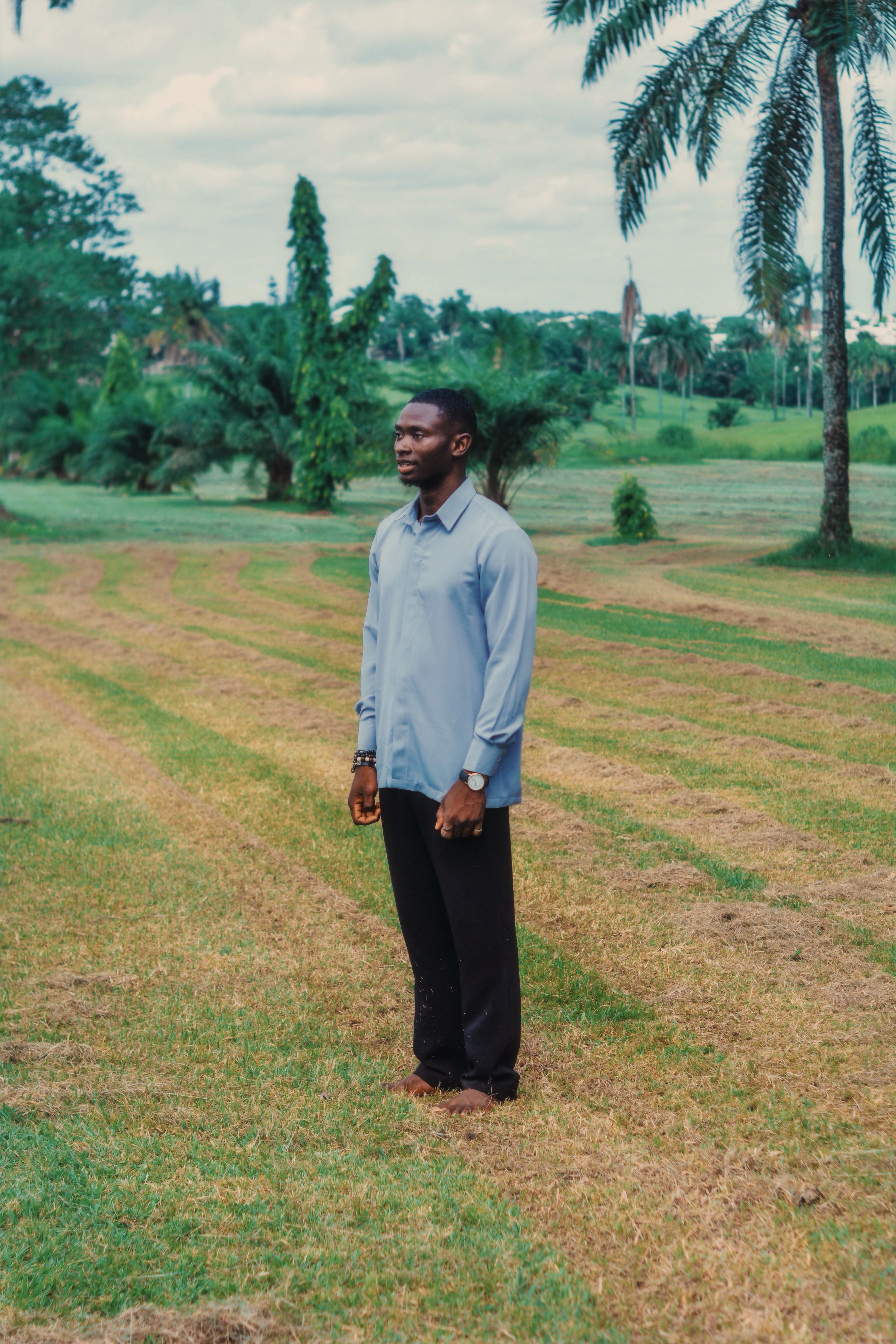 Man Standing in Lush Tropical Park Setting · Free Stock Photo