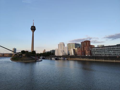 Free Scenic view of Düsseldorf's Rhine riverside featuring the iconic Rheinturm tower at dusk. Stock Photo