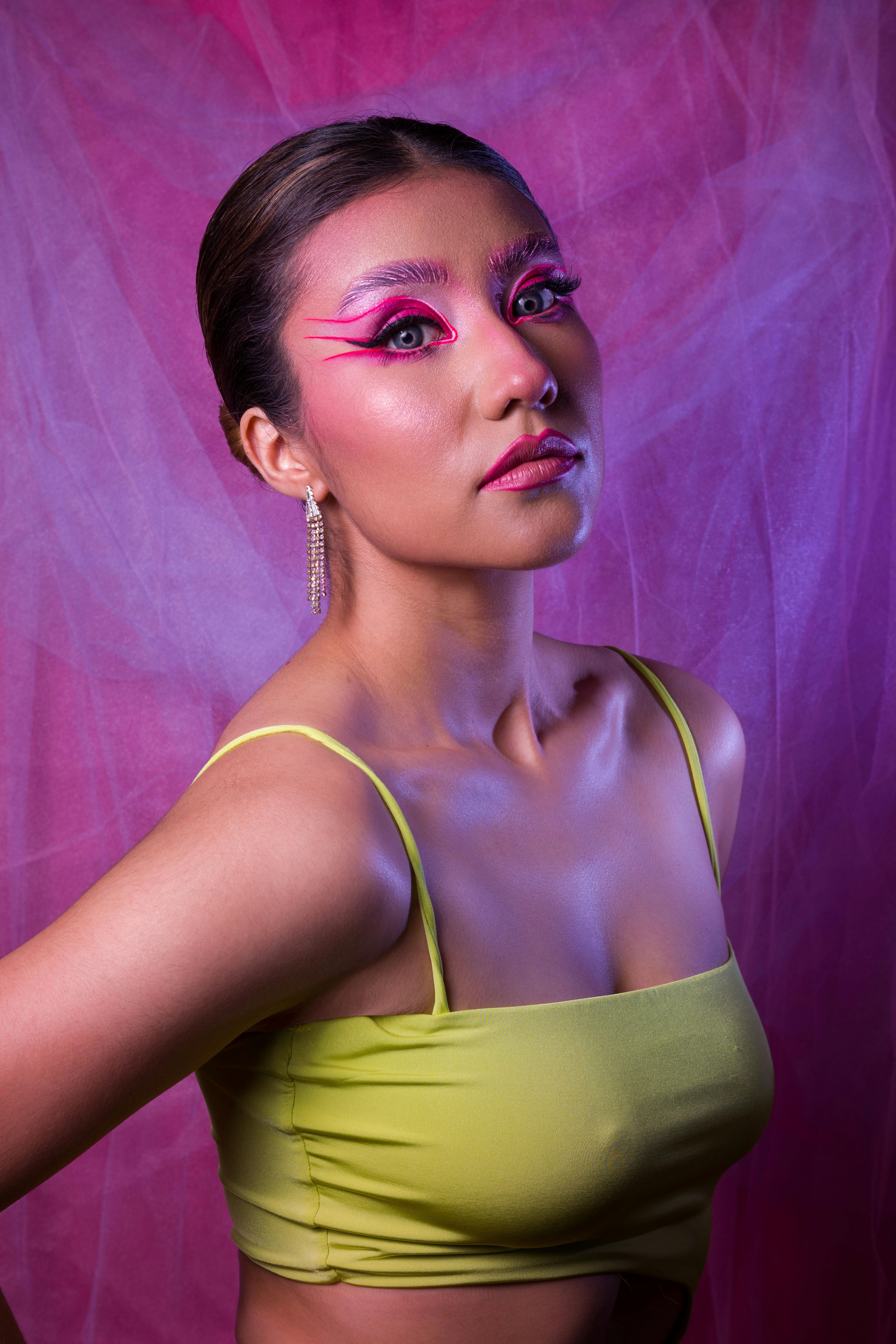 Striking portrait of a woman in artistic makeup and vibrant attire, perfect for fashion use.