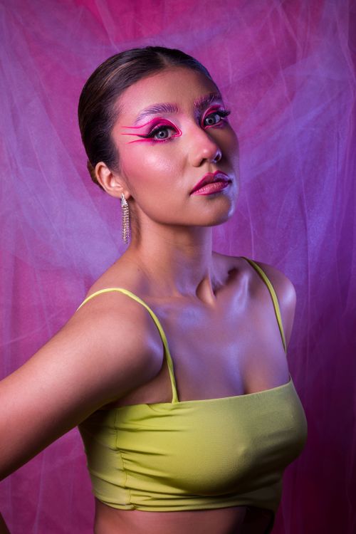 Free Striking portrait of a woman in artistic makeup and vibrant attire, perfect for fashion use. Stock Photo