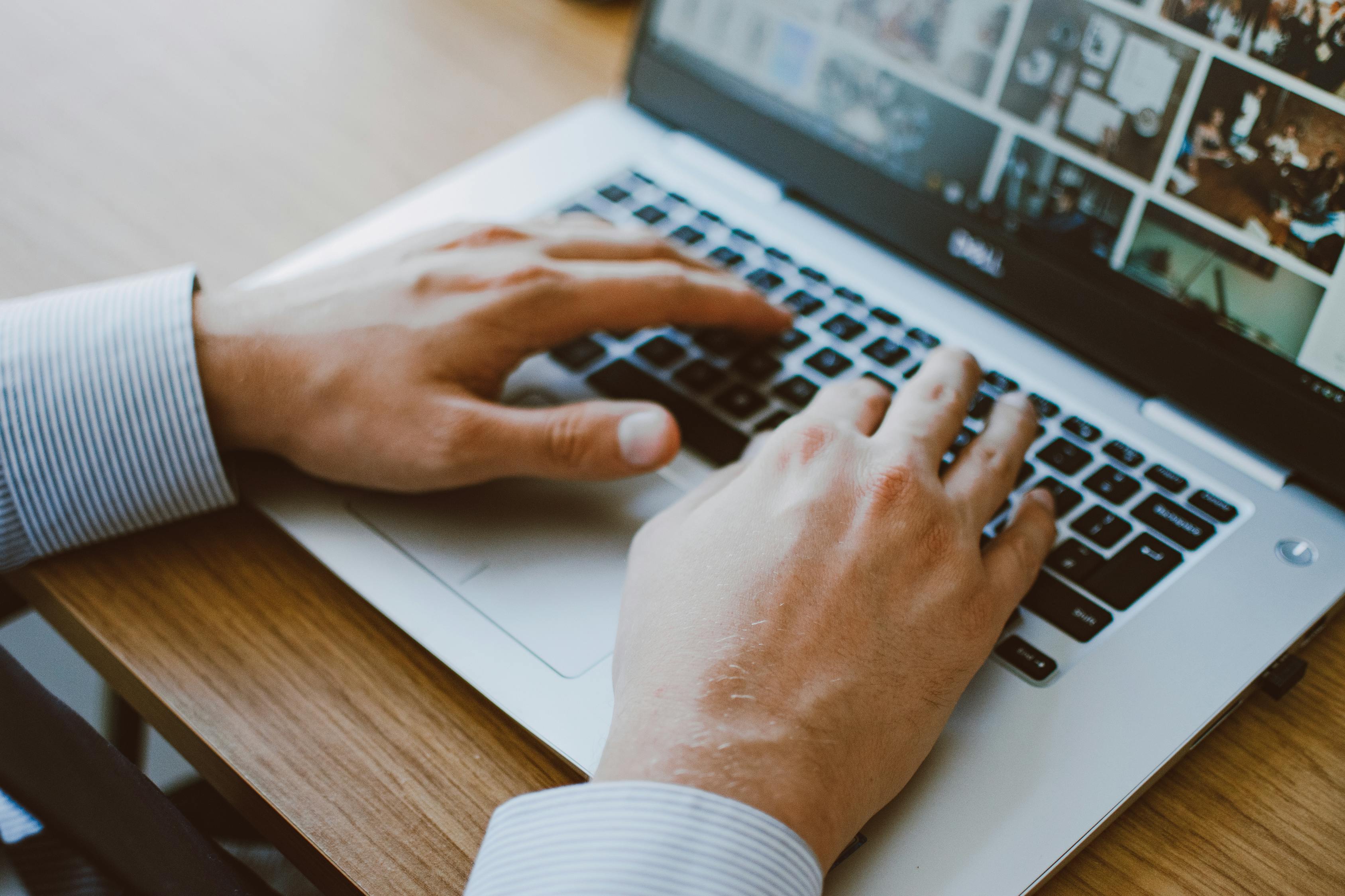  A person is using a laptop with a touchpad while sitting at a desk in a modern office.