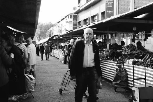 Street market bustling with shoppers captured in a timeless black and white photograph.