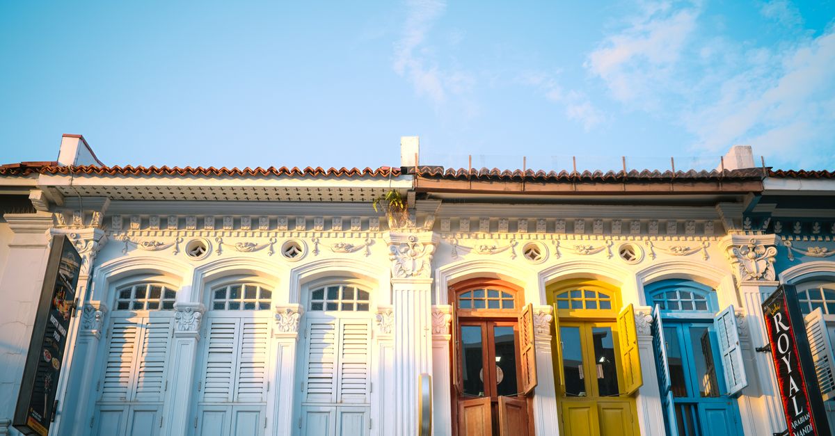A row of colourful restored shophouses on a sunlit street