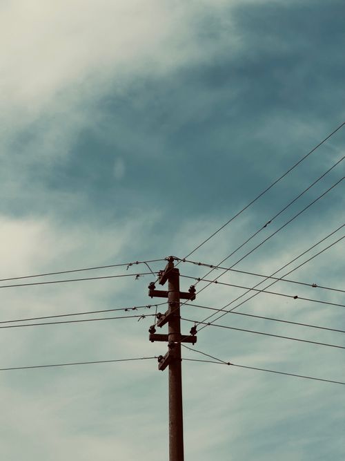 Free Electric pole with multiple wires against a partly cloudy blue sky, with a vintage tone. Stock Photo