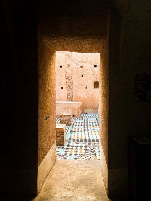 Free A view through a doorway into a vibrant Moroccan courtyard in Marrakech, Morocco. Stock Photo