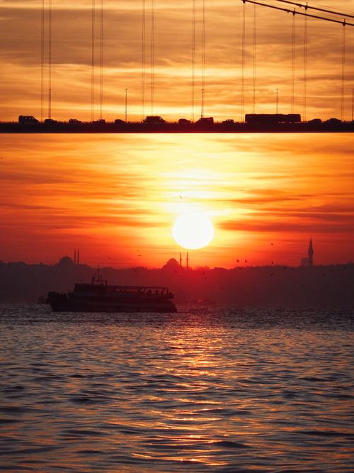 Free A stunning sunset over the Bosphorus featuring a bridge and silhouette of a cityscape. Stock Photo