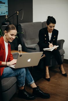 职业女性们在时尚的办公室里一起使用笔记本电脑工作并做笔记