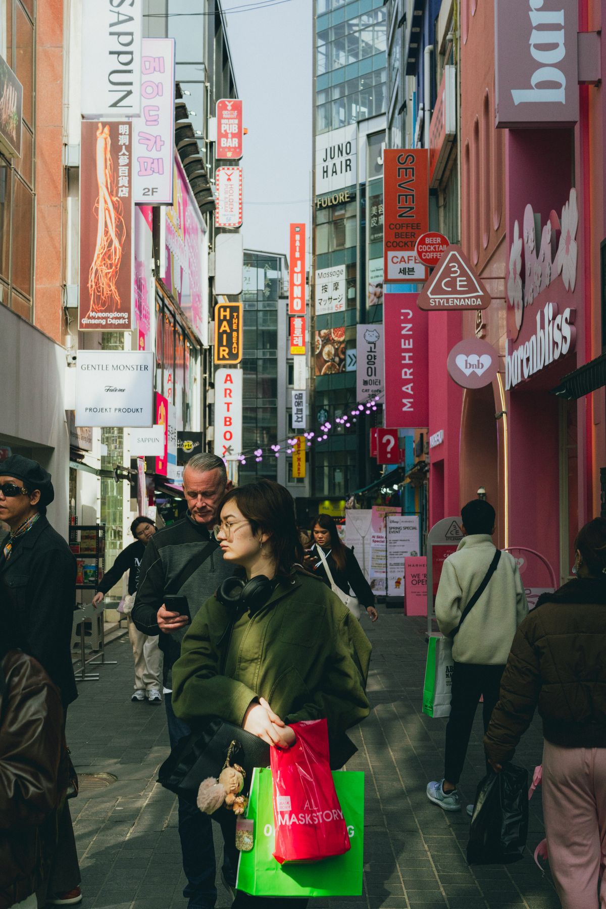 Shop signs above a busy shopping street in Myeongdong