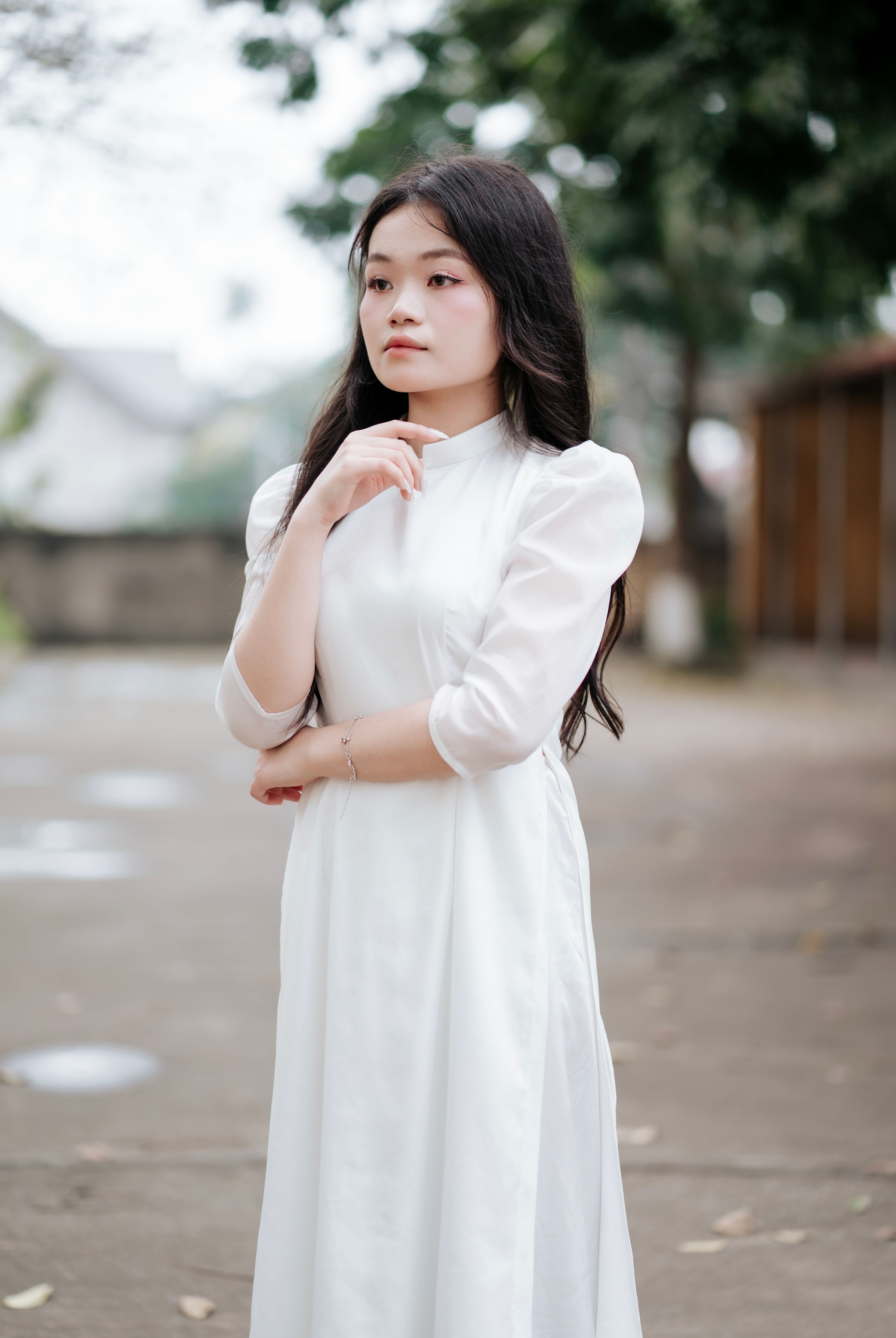 Elegant Woman in White Ao Dai Posing Outdoors · Free Stock Photo