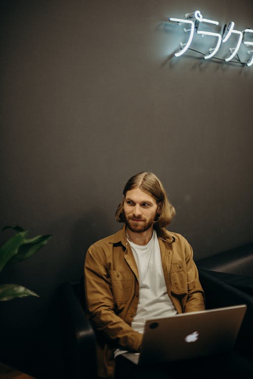 Mann, Der Braune Jacke Mit Laptop Computer Trägt