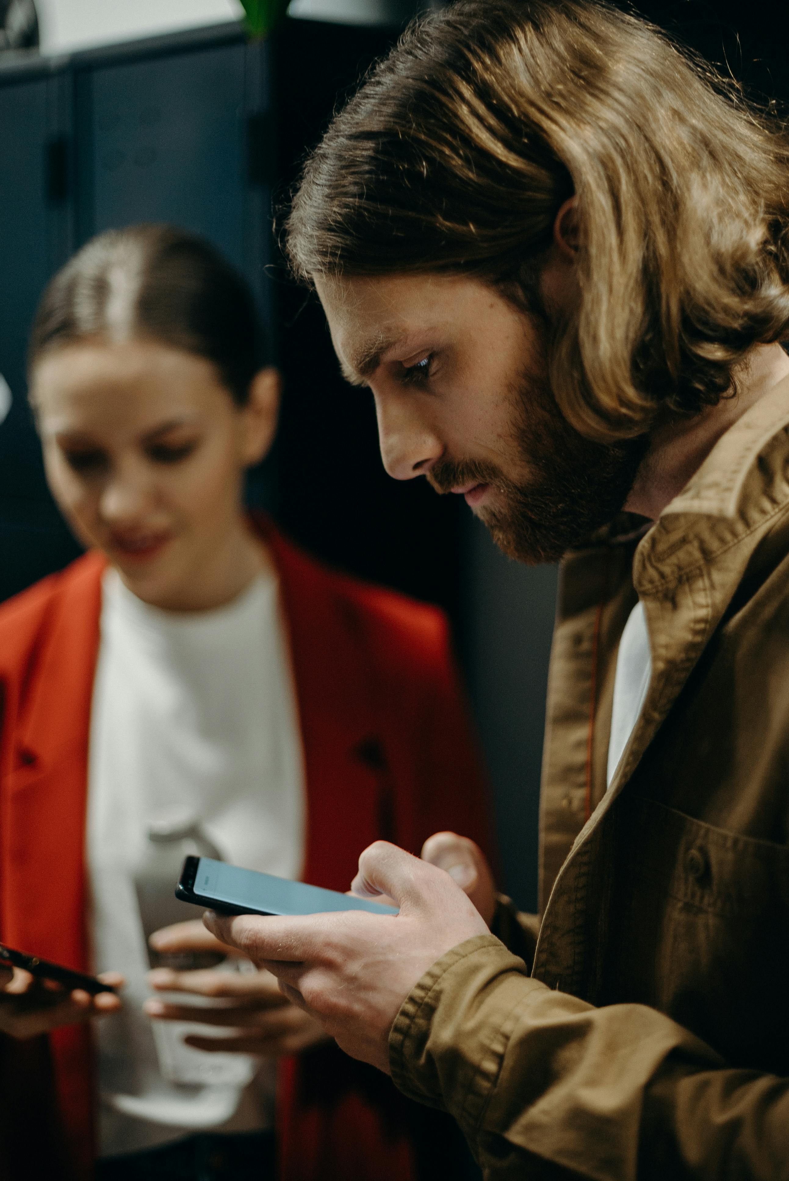 Man and woman using their mobile phones. | Photo: Pexels