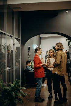 在一个充满活力的现代室内环境中，人们正进行着休闲的办公室聚会交谈