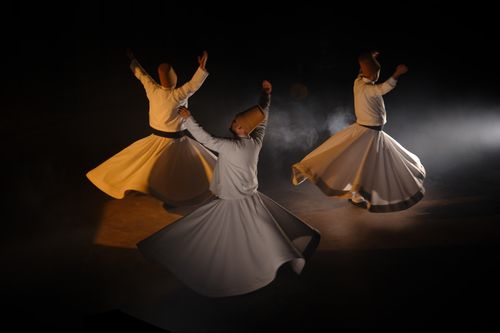 Free Three dervishes perform Sufi whirling, creating a mystical and spiritual ambiance. Stock Photo