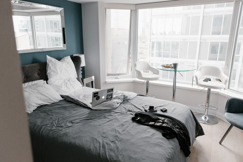 Chambre d'hôtel avec vue panoramique sur la ville depuis une grande baie vitrée