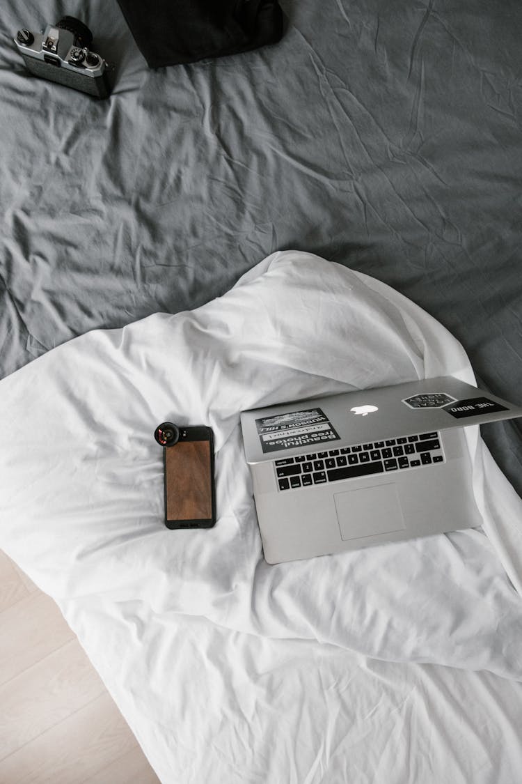 Macbook Beside Iphone On White Linen